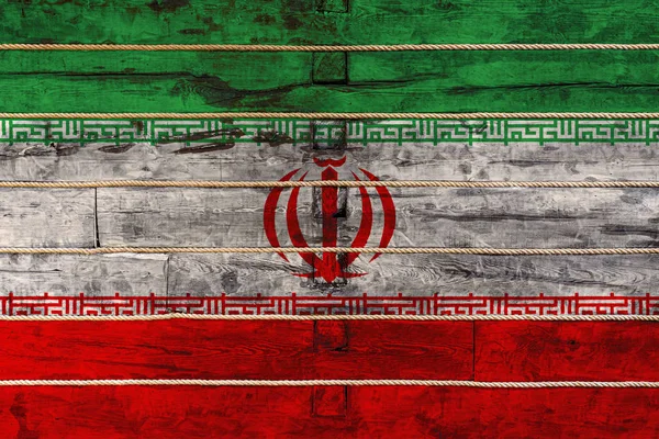 National flag  of Iran on a wooden wall background. The concept of national pride and a symbol of the country. Flags painted on a wooden fence with a rope