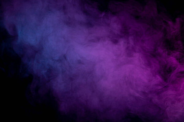 Cloud of purple and pink smoke in the form of a skull, monster, dragon on a black isolated background. Background from the smoke of vape.