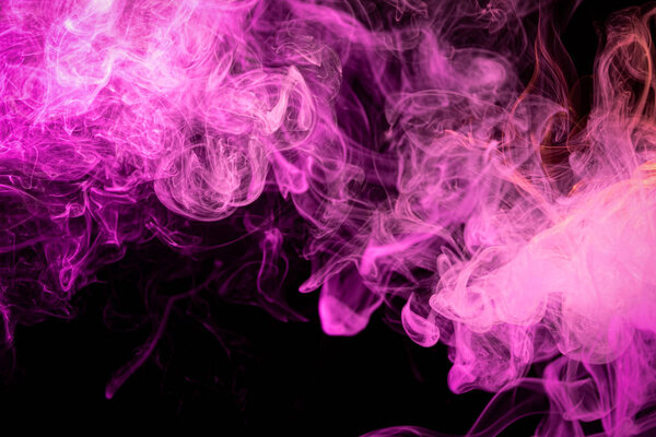 Colorful pink and red smoke on a black isolated background. Background from the smoke of vape. Abstract artwork.