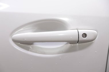 Beyaz bir arabanın yakın kapı kolu.