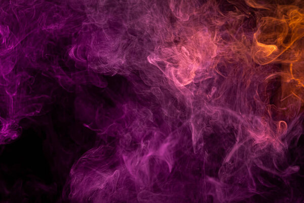 Colorful pink and red smoke on a black isolated background. Background from the smoke of vape. Abstract artwork.