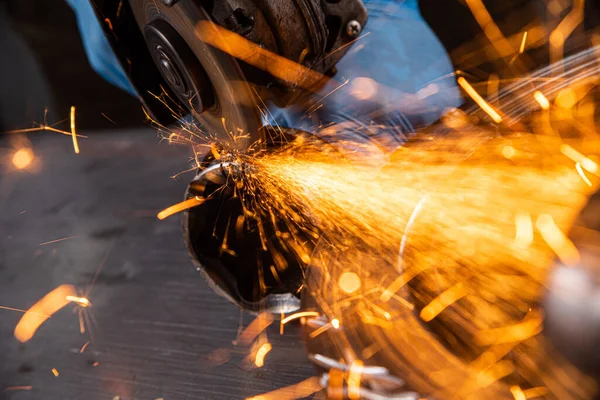 ワークショップでは 若い男溶接研削盤金属角度研削盤 火花側に飛ぶ 金属と工場で働く溶接機 — ストック写真