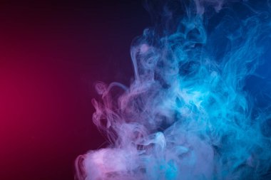 Siyah arkaplanda renkli mavi ve pembe buhar dumanlarını mistik ve muhteşem biçimlerde kapatıyoruz. Sanat için mobese.