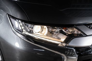 Novosibirsk, Rusya 10 Şubat 2020: Mitsubishi Outlander, Macro modern gri araba ksenon lamba, tampon, tekerlek manzarası. Modern bir arabanın dışı.