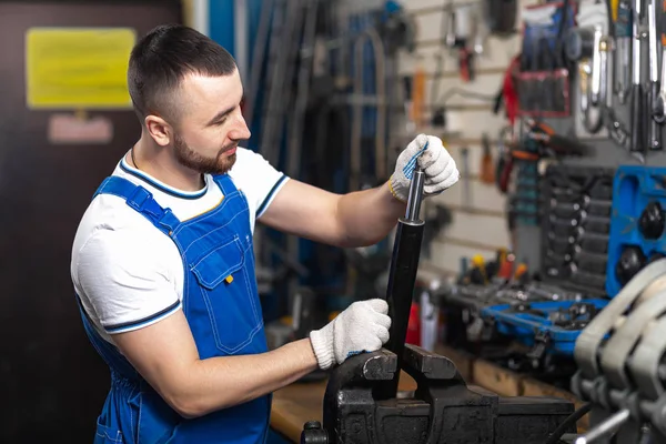 Ein Junger Mann Mechaniker Overalls Repariert Seinem Arbeitsplatz Einen Stoßdämpfer — Stockfoto