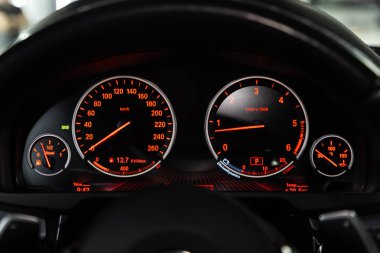 Novosibirsk, Russia  February 12, 2020:  BMW X5, dashboard of the car is illuminated by bright illumination. Speedometer, circle tachometer, oil and fuel level