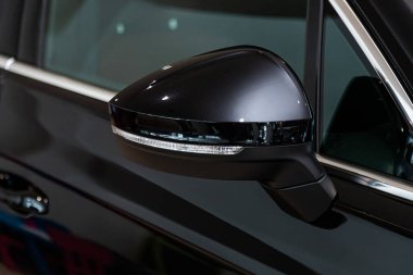 Dönüş sinyali yineleyicili arabanın siyah yan aynası. Dışarıdaki yeni araba