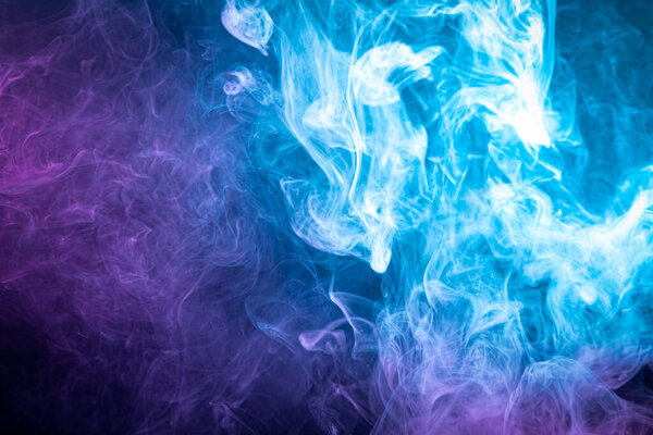 Cloud of pink and blue smoke on a black isolated background. Background from the smoke of vape
