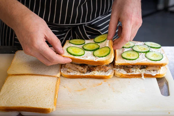 Close Male Chef Black Apron Puts Burger Out Bread Spread — Stock Photo, Image