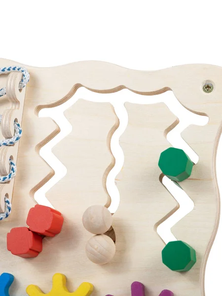Wooden eco-friendly busy board - educational toy for children, babies on a white isolated background, consisting of multi-colored wooden puzzle pieces, maze, gear, sorter