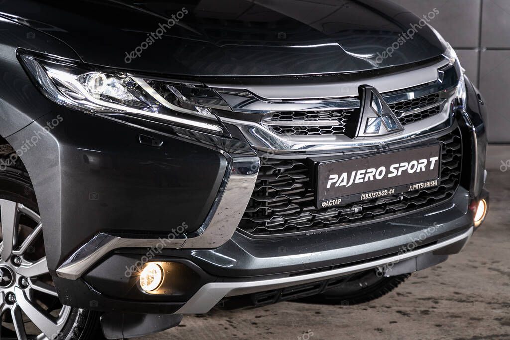Novosibirsk, Russia  February 10, 2020:  Mitsubishi Pajero Sport,close-up of the headlight, bumper, wheel, logo radiator grille, hood. Photography of a modern car on a parking in Novosibirsk