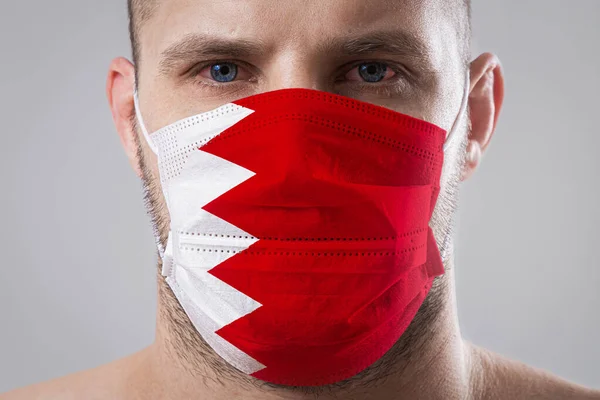 Mladý Muž Bolavýma Očima Lékařské Masce Namalované Barvách Bahrajnské Národní — Stock fotografie