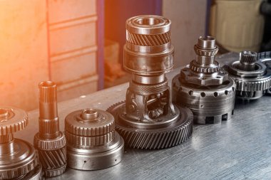 Çeşitli motor ve yedek şanzıman parçaları seti. Gezegen şanzımanı için parlak vitesler. Metal ototeknoloji arka planı. Tekerlek motoru dişlileri, kapatın.