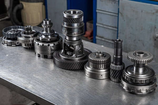 Набор различных запчастей для двигателей и редукторов. Shiny gears for planetary gearbox.autotechnology background. редукторы, закрыть
