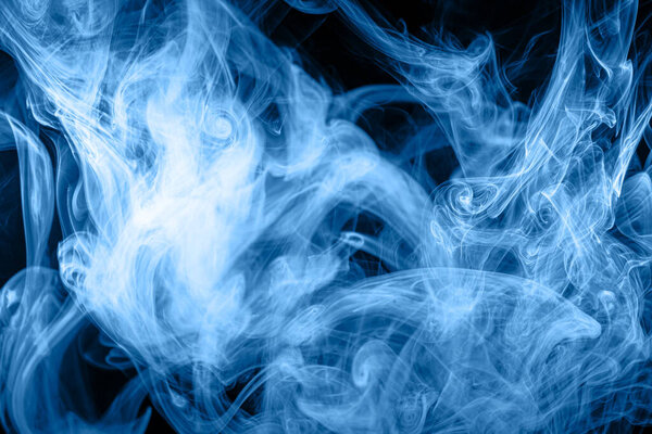 Dense multicolored smoke of blue and purple colors on a black isolated background. Background of smoke vap