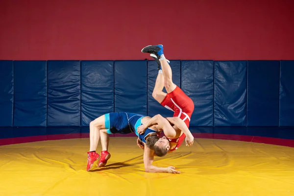 スポーツレスリングのタイツとレスリングの伝統的なギリシャ ローマのレスリングのマットでの戦いで2人の男性 レスラーは相手の胸を通して — ストック写真