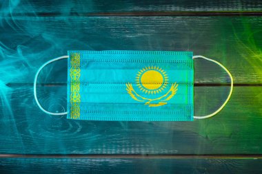 Kazakistan bayrağında resmedilen hava hastalıklarına karşı korunmak için tıbbi maske.
