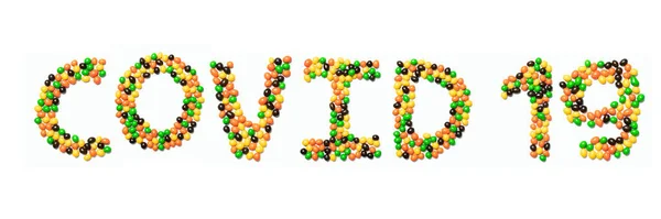 Напис Covid Англійського Алфавіту Різнокольорових Круглих Шоколадних Цукерок Білому Ізольованому — стокове фото