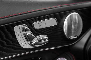 Yeni bir arabanın kapı kontrol paneline yakın çekim. Pencere kontrol paneli, kapı kilidi, koltuk ayarlama düğmeleri ve ayna kontrollü kol dinlenmesi.