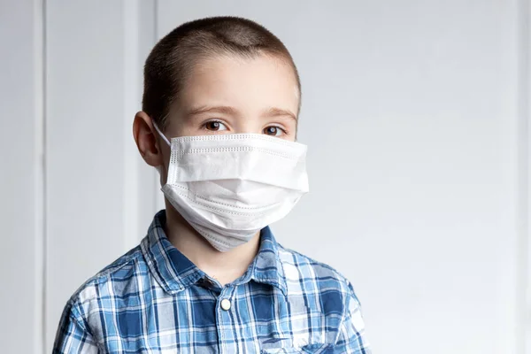 年轻的男孩戴着医疗面罩 眼睛疼痛 看着相机 对空气传播疾病的医疗保护 验尸官 希尔德害怕得流感 — 图库照片
