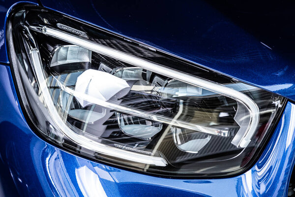 Close up of the car detailing: beauty clean headlights of  blue sedan