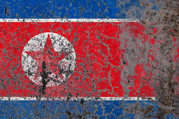 National flag of North Korea on old peeling wall background.The concept of national pride and symbol of the country.