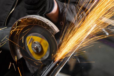 Bir oto tamir için arka plan araçları farklı yönlerde uçan parlak yanıp söner bir oto tamircisi mengeneye içinde bir araba sessiz blok kesmek için bir metal taşlama kullanarak bir araba tamircisi bir close-up