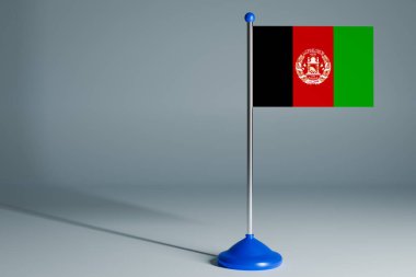 Afganistan 'ın 3D gerçekçi ulusal bayrağını gri izole arka planda çelik direğe asıyor. Boş masa bayrağı, tasarım için uygun, alaycı