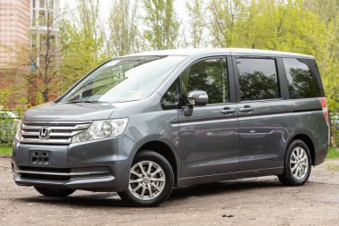 Novosibirsk / Rusya Mayıs 02 2020: Honda Stepwagon, yeşil sokağa park edilmiş modern gri minivanın ön görüntüsü. 