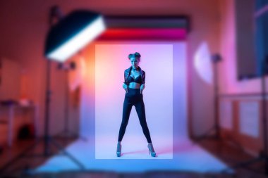 Bir fotoğraf stüdyosundaki zarif, ince bir kadın ve parlak pembe neon ışıklarıyla ilgili bir katalog için fotoğraf çekiyordum. Bir giyim mağazası için moda çekimi konsepti.