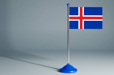 İzlanda 'nın 3D gerçekçi ulusal bayrağını izole edilmiş gri arka planda çelik direğe asıyor. Boş masa bayrağı, tasarım için uygun, alaycı