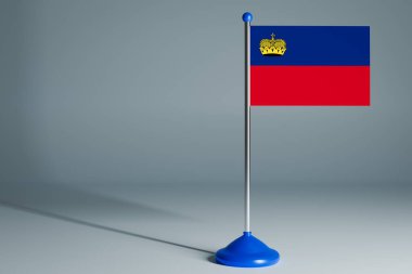 Lihtenştayn 'ın 3D gerçekçi ulusal bayrağını gri yalıtılmış arka planda çelik direğe dikmek. Boş masa bayrağı, tasarım için uygun, alaycı