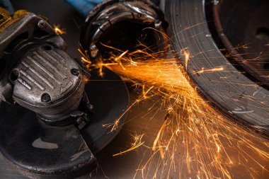 Yakın çekim parlak taraf anında açı kıyma makinesinden kıvılcım. Genç bir erkek kaynakçı bir beyaz eldiven çalışma açısı değirmeni garajda ile metal ürün biler
