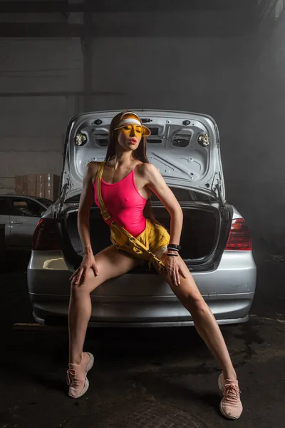 Modell Stilvoller Kleidung Bunten Hellen Neonlichtern Sitzt Auf Offenen Kofferraum — Stockfoto