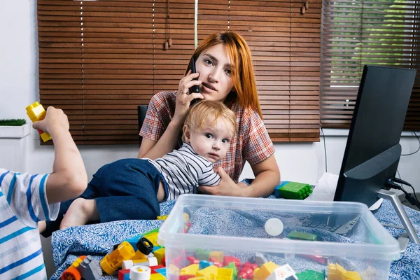 Anya Két Kisfiúval Térdén Megpróbál Otthon Nevetni Egy Fiatal Vigyáz — Stock Fotó