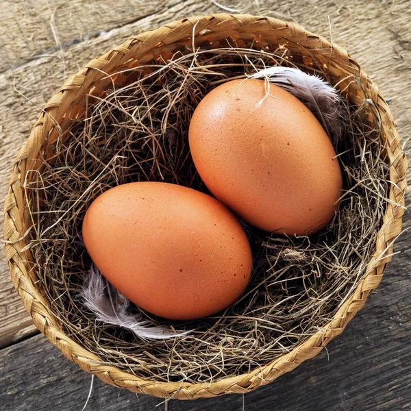 Couple Fresh Chicken Eggs Rural Basket Hey Feather Wooden Background — Stock Photo, Image