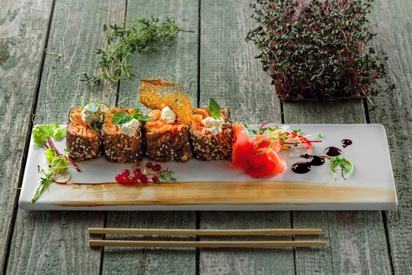 Fresh salmon rolls with pickled ginger and soy sauce. Healthy Japanese food made of salmon fish on a table. Traditional sashimi meal.