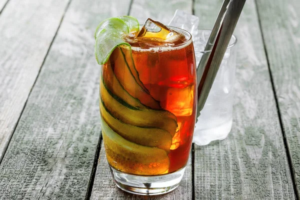 美味的酒精鸡尾酒饮料与黄瓜 可乐和白兰地在一个木桌上 经典鸡尾酒加冰块 特写镜头 — 图库照片