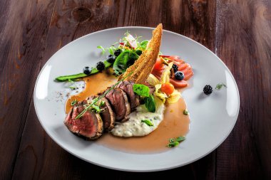 Lezzetli orta pişmiş biftek, sos ve salata. Et fileto ve sebzeden yapılmış gurme yemeği. Lezzetli sağlıklı yemek..