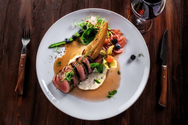 Lezzetli orta pişmiş biftek, sos ve salata. Et fileto ve sebzeden yapılmış gurme yemeği. Lezzetli sağlıklı yiyecekler. Üst görünüm.