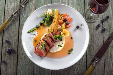 Lezzetli orta pişmiş biftek, sos ve salata. Et fileto ve sebzeden yapılmış gurme yemeği. Lezzetli sağlıklı yiyecekler. Üst görünüm.