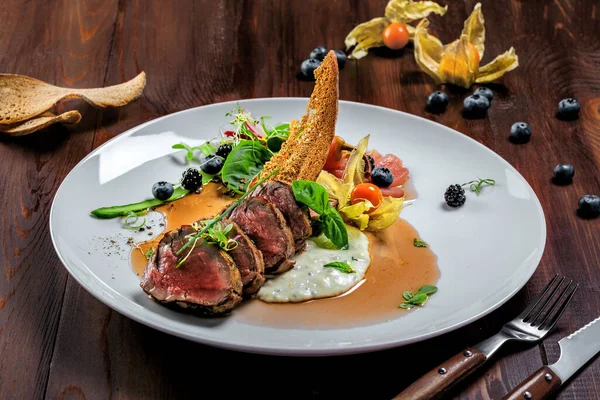 Lezzetli orta pişmiş biftek, sos ve salata. Et fileto ve sebzeden yapılmış gurme yemeği. Lezzetli sağlıklı yemek..