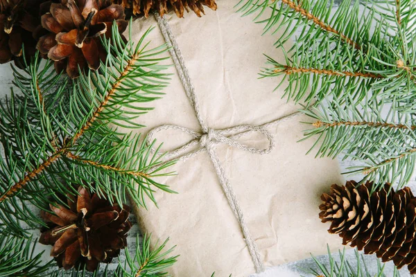 Weihnachtsgeschenk mit Tannenzapfen und Tannenzweigen — Stockfoto