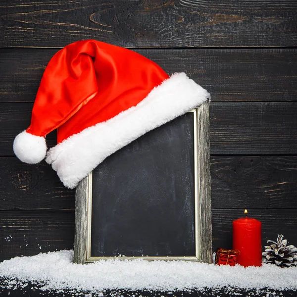 Rött Santa hatt på tavlan med snö — Stockfoto