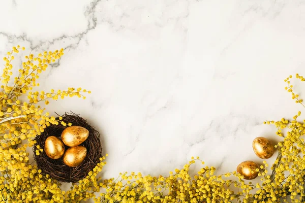 Arany Fürjtojás Kis Fészekben Sárga Színű Mimózavirágokkal Márványasztalon Boldog Húsvéti — Stock Fotó