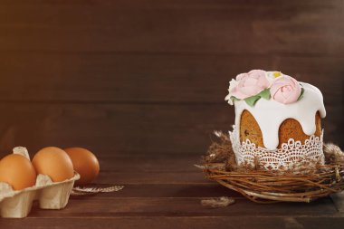 Paskalya kırsalında. Yuvada el yapımı kek ve ahşap arka planda yumurtalar. Tatil konsepti. Mutlu Paskalyalar, kopyalama alanı