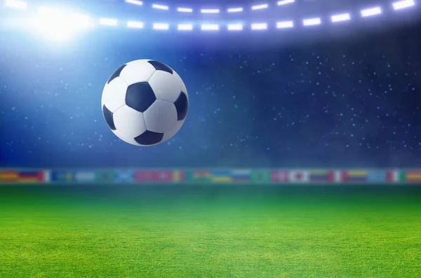Bola de fútbol, proyector brillante ilumina campo de fútbol verde —  Fotos de Stock