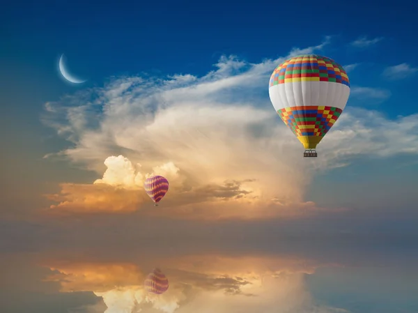 Hete lucht ballonnen vliegt in gloeiende avondrood boven kalme zee — Stockfoto