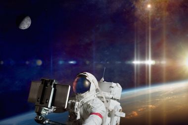 Astronaut taking selfie photo in space on orbit of planet Earth clipart