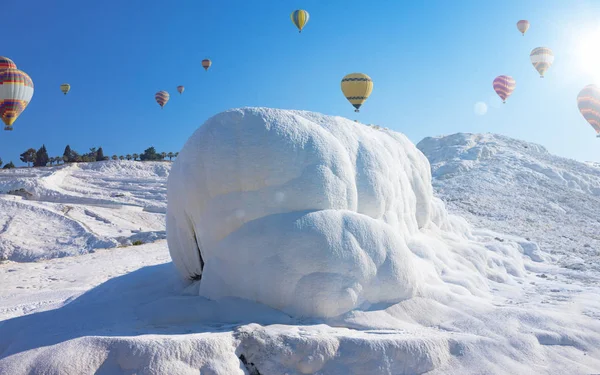 Hot air ballons flying above snowy white Pamukkale in Turkey — Stock Photo, Image